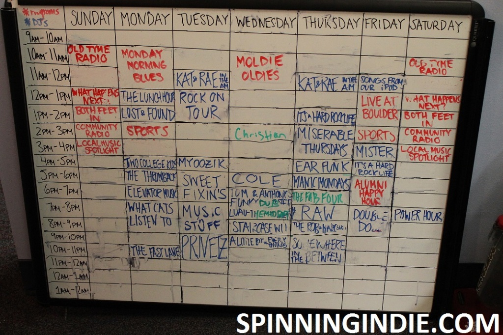 white board with college radio station WLOY's schedule