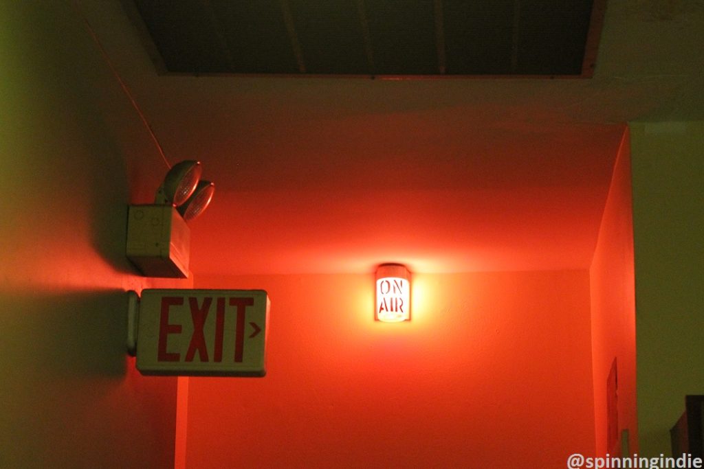 The glow of the on-air sign at community radio station KABF. Photo: J. Waits