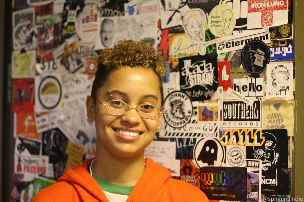 Micah Fedenko in front of sticker-covered cabinet at Vassar College radio station WVKR. Photo: J. Waits