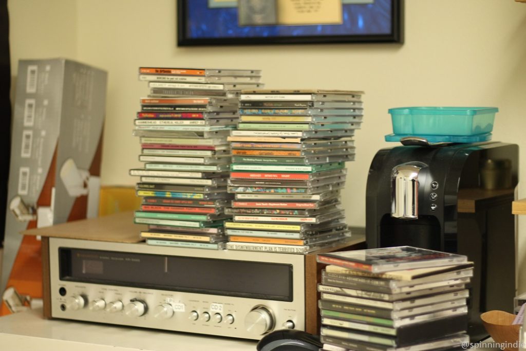 CDs stacked atop audio receiver in office at KBCS. Photo: J. Waits/Radio Survivor