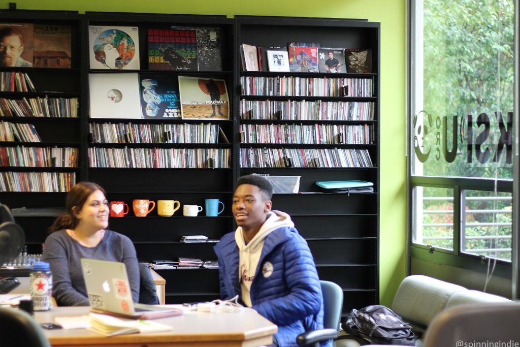 Taylor Muñoz and Michael Miller in KSPU studio, with shelves of CDs behind them. Photo: J. Waits/Radio Survivor