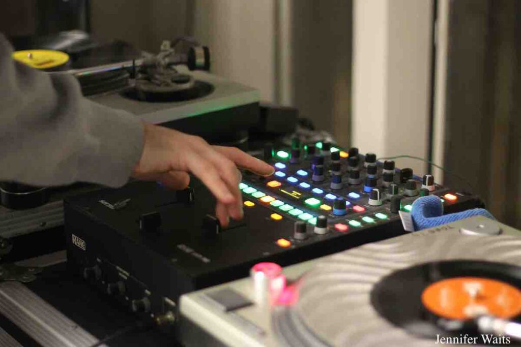 DJ in studio at college radio station WCDB. Photo of hand on mixer, with vinyl on adjacent turntables. Photo: J. Waits