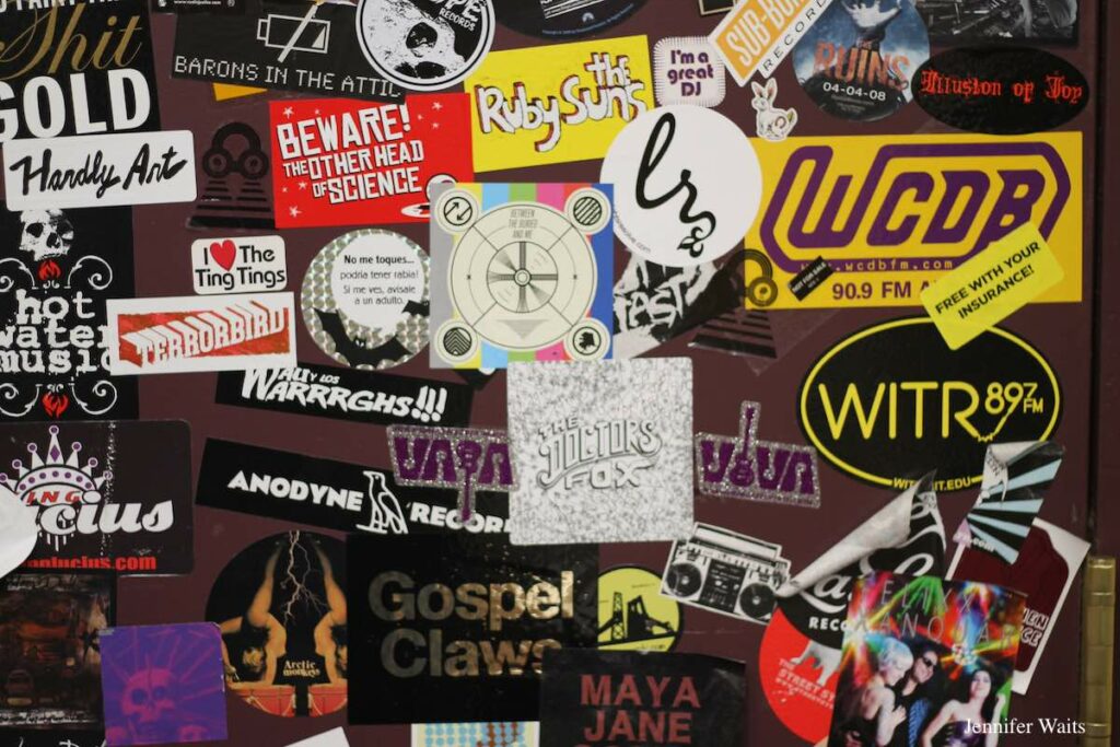 Photo of college radio station cabinet at WCDB plastered with stickers, including WCDB sticker. Photo: J. Waits