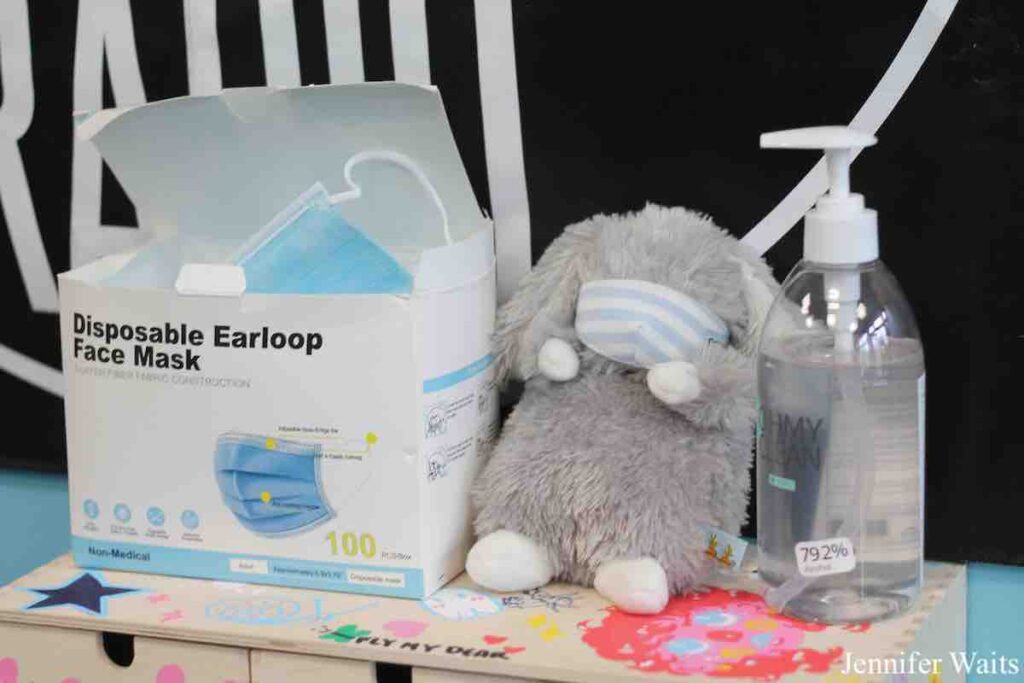 Photo of a box of disposable face masks, a masked stuffed animal bunny, and a bottle of hand sanitizer at college radio station WSLC. Photo: J. Waits