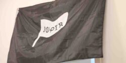 Photo of black flag with image of white flag with WPIR logo on it. At college radio station WPIR Pratt Radio. Photo: J. Waits