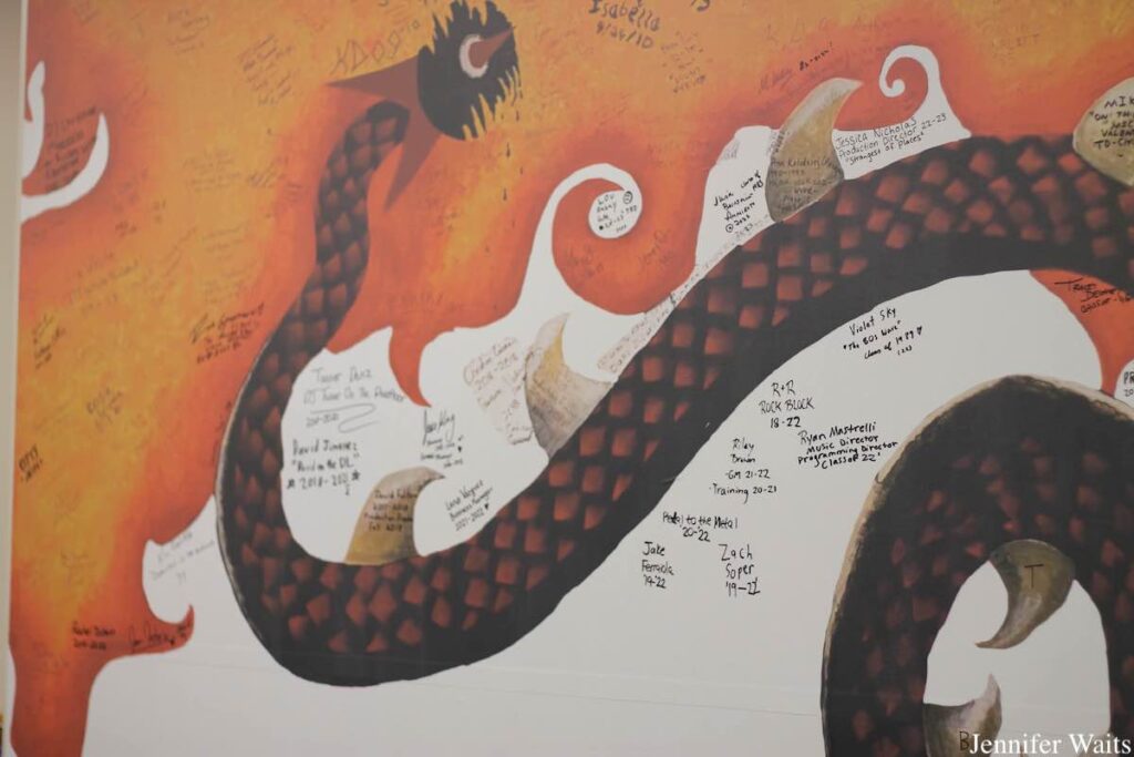 Photo of mural depicting part of a dragon. Drawn on the mural are signatures and dates from alumni of college radio station WONY-FM. Photo: J. Waits