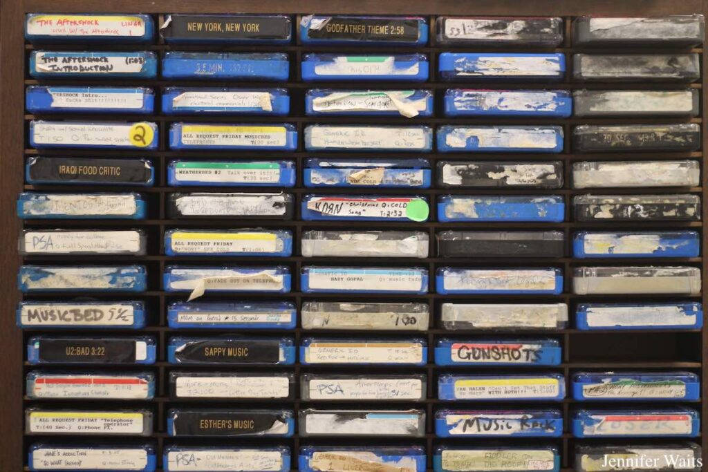 Photo of carts at college radio station WONY-FM. Carts have old, peeling labels reading "music bed," "New York, New York," "Music Rock," and more. Photo: J. Waits