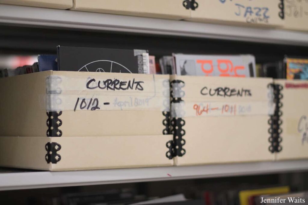 Boxes of CDs on shelves at college radio station WBGU-FM. Boxes are labeled "currents," and "jazz." Photo: J. Waits