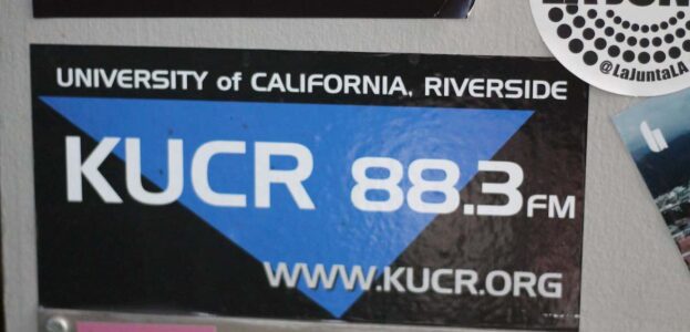 Photo of wall at college radio station KUCR, with KUCR 88.3 sticker in the center. Photo: J. Waits